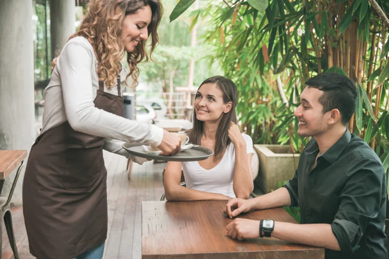 Pareja madura disfrutando café sostenible en una mesa al aire libre